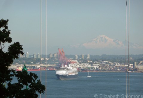 A cruise ship sails out of Vancouver's Burrard Inlet, with Washington's Mount Baker in the distance.